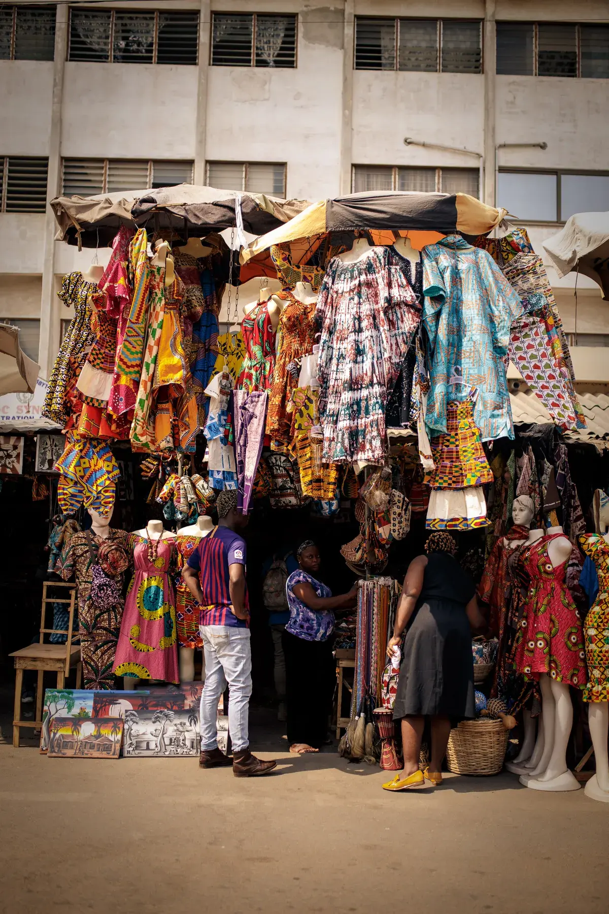 Racks of printed fabric at a market.