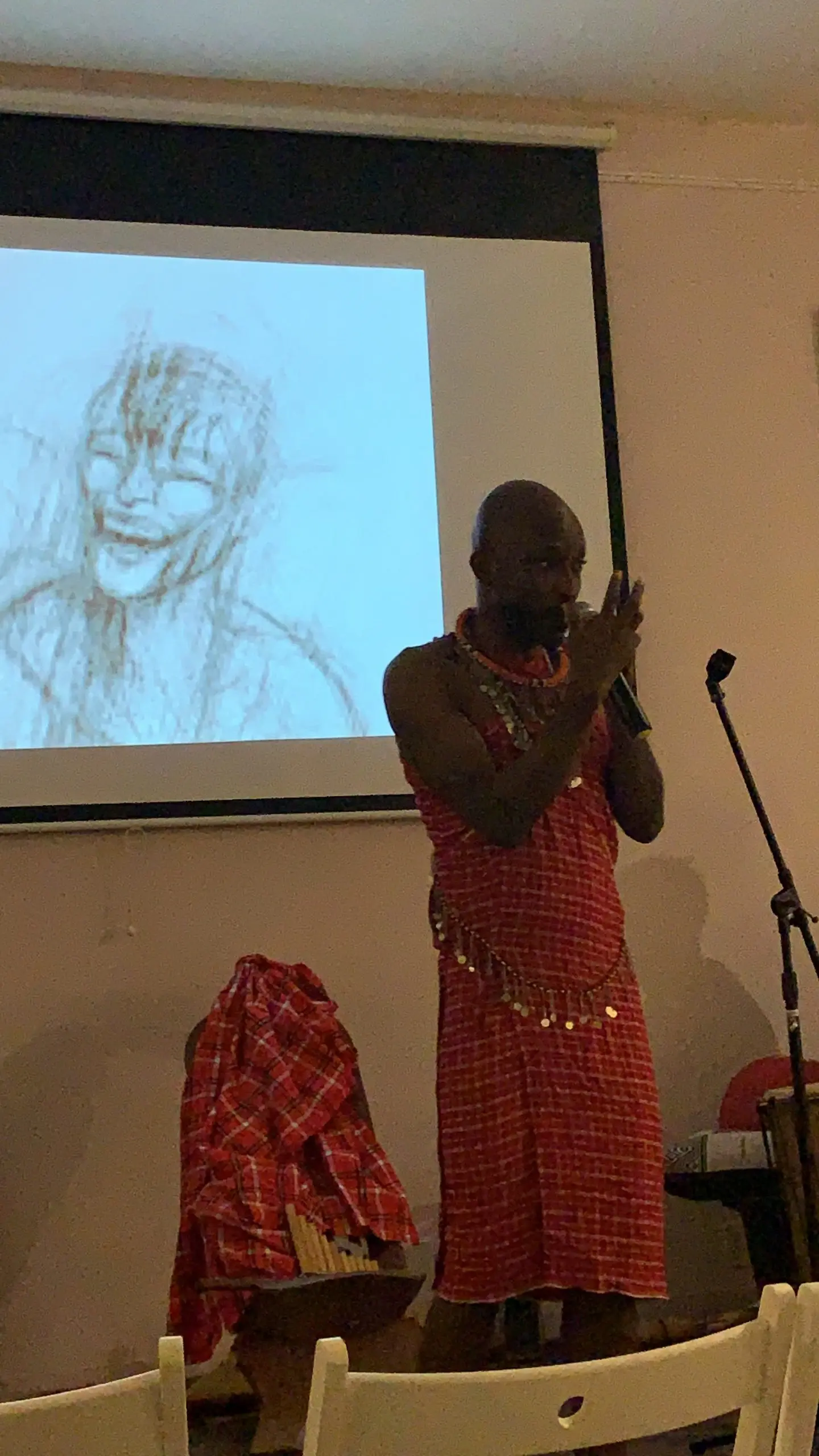 Richard Meseko performing in front of a projected drawing.