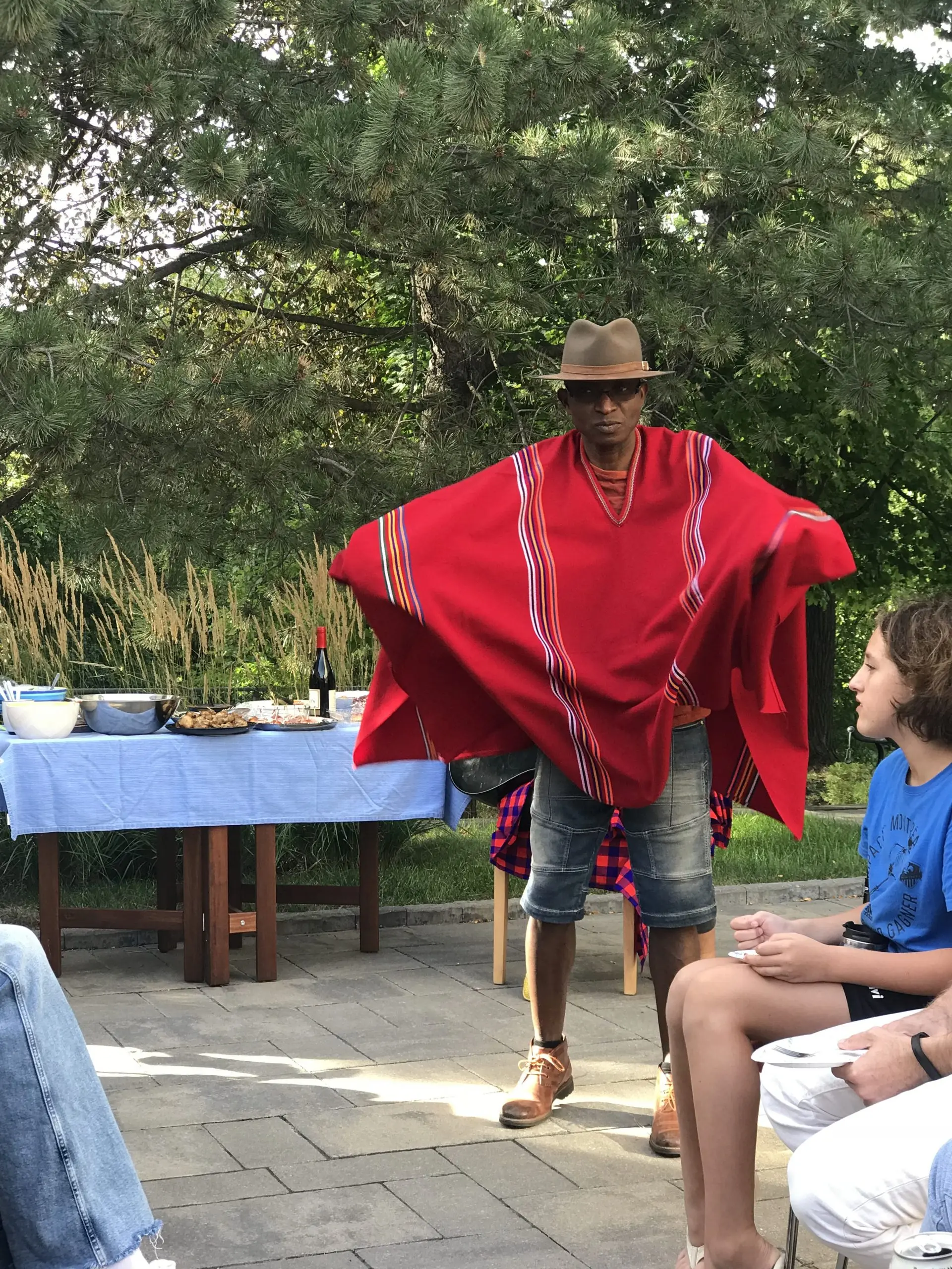 Richard Meseko spreading a red cloak outdoors.