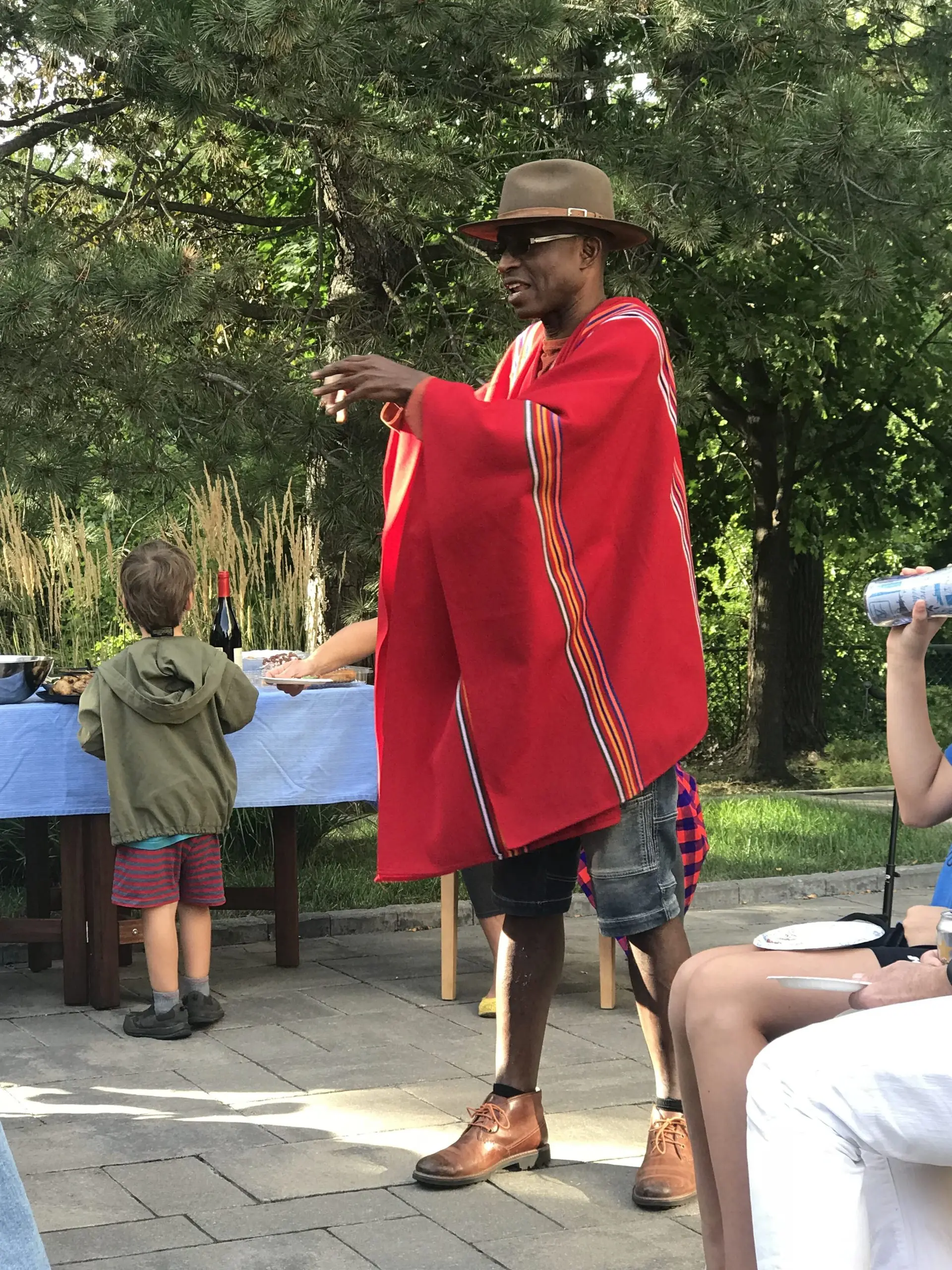Richard Meseko in a red cloak at an outdoor gathering.