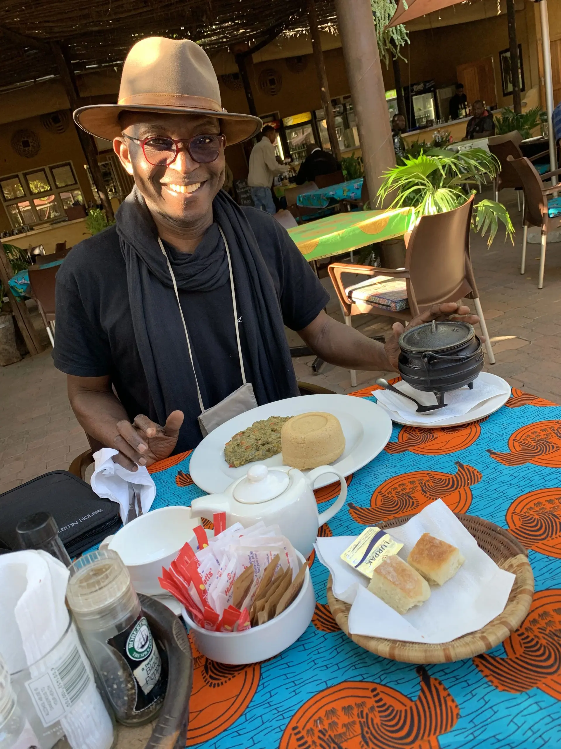 Richard Meseko in a hat at a lunch table.