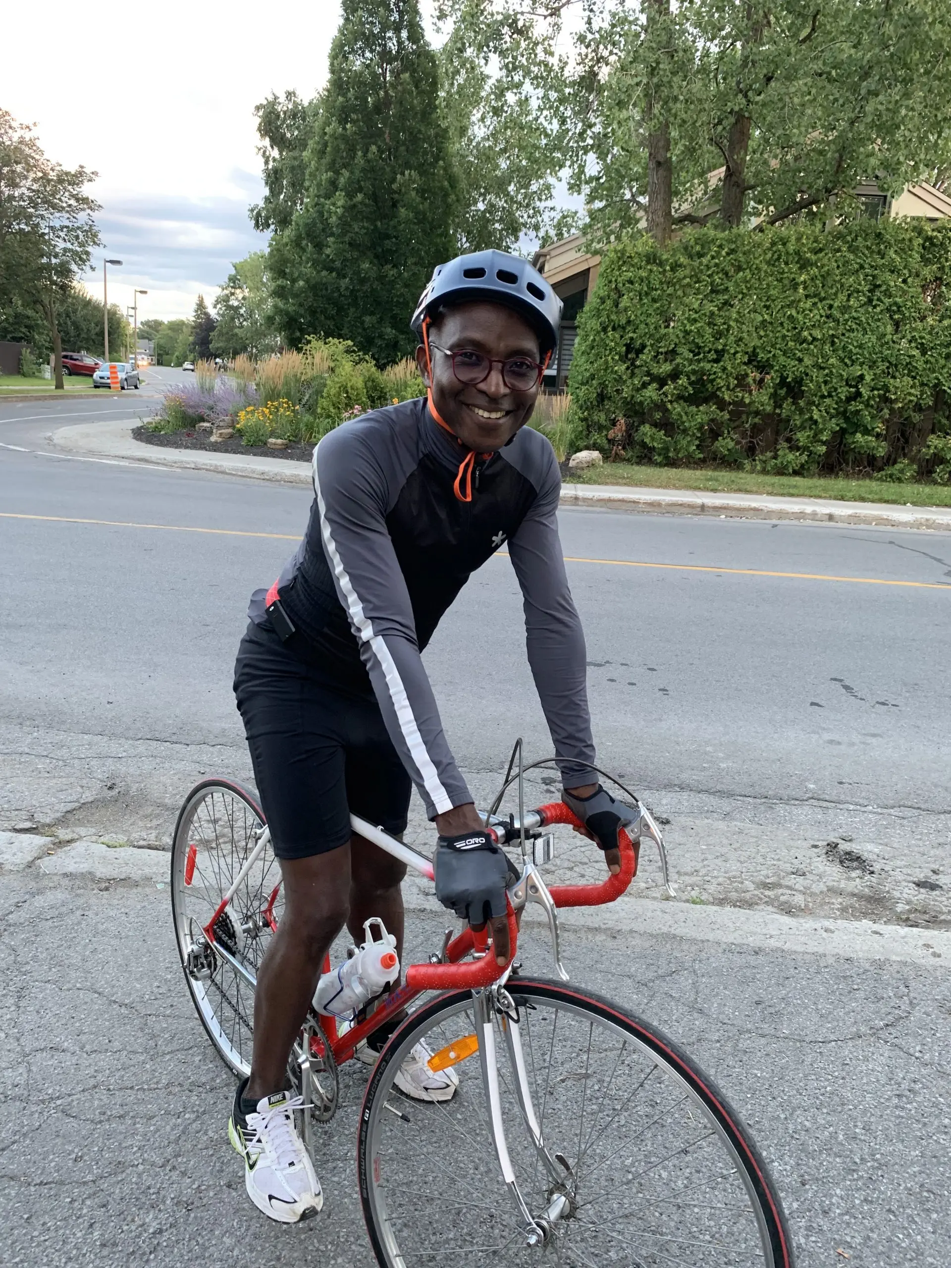 Richard Meseko in a cycling helmet on a road bike.