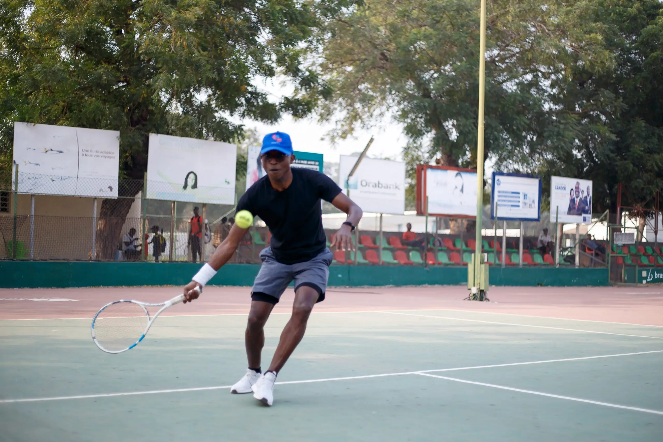 Richard Meseko returning a ball on a tennis court.