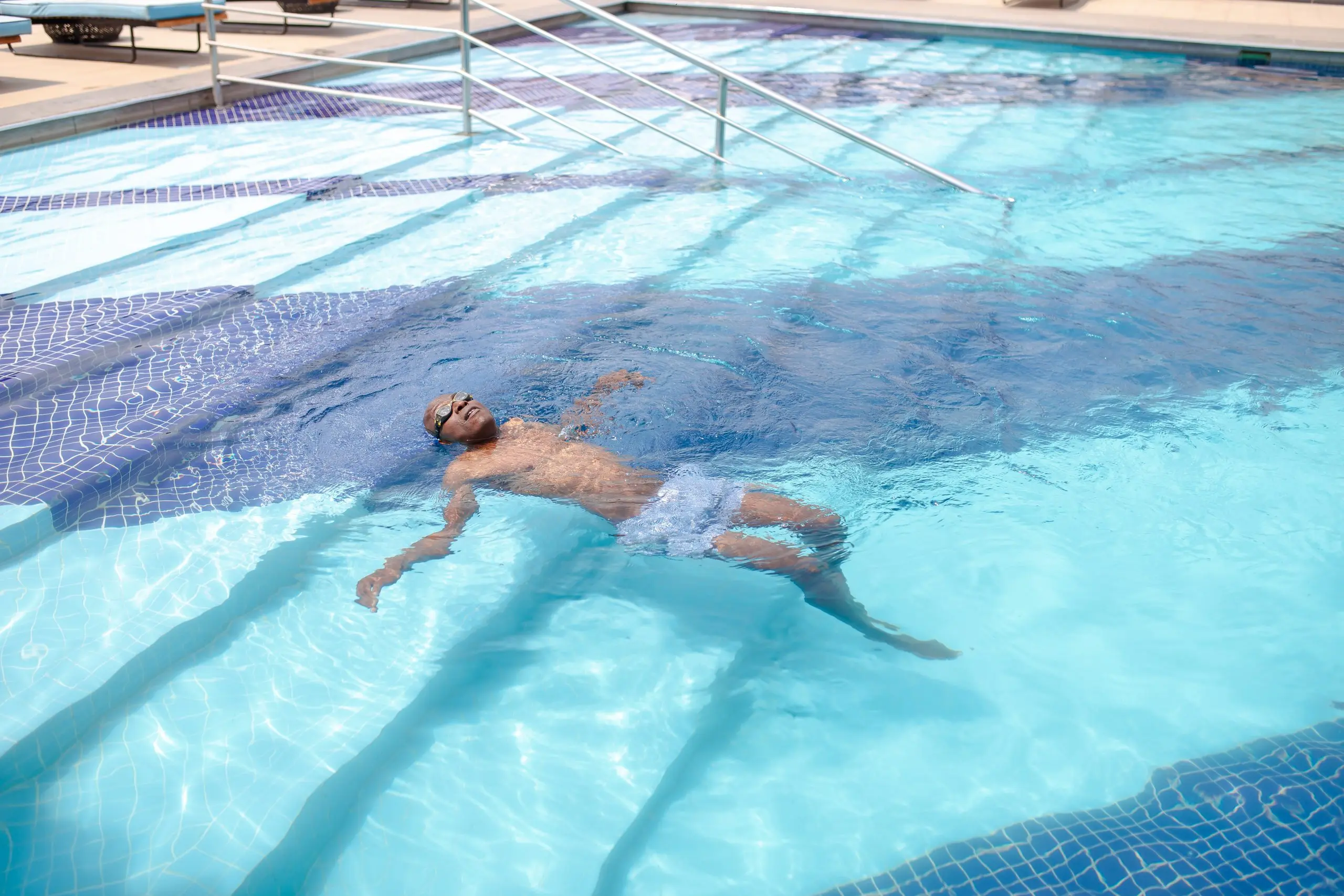 Richard Meseko swimming on his back in a blue pool.