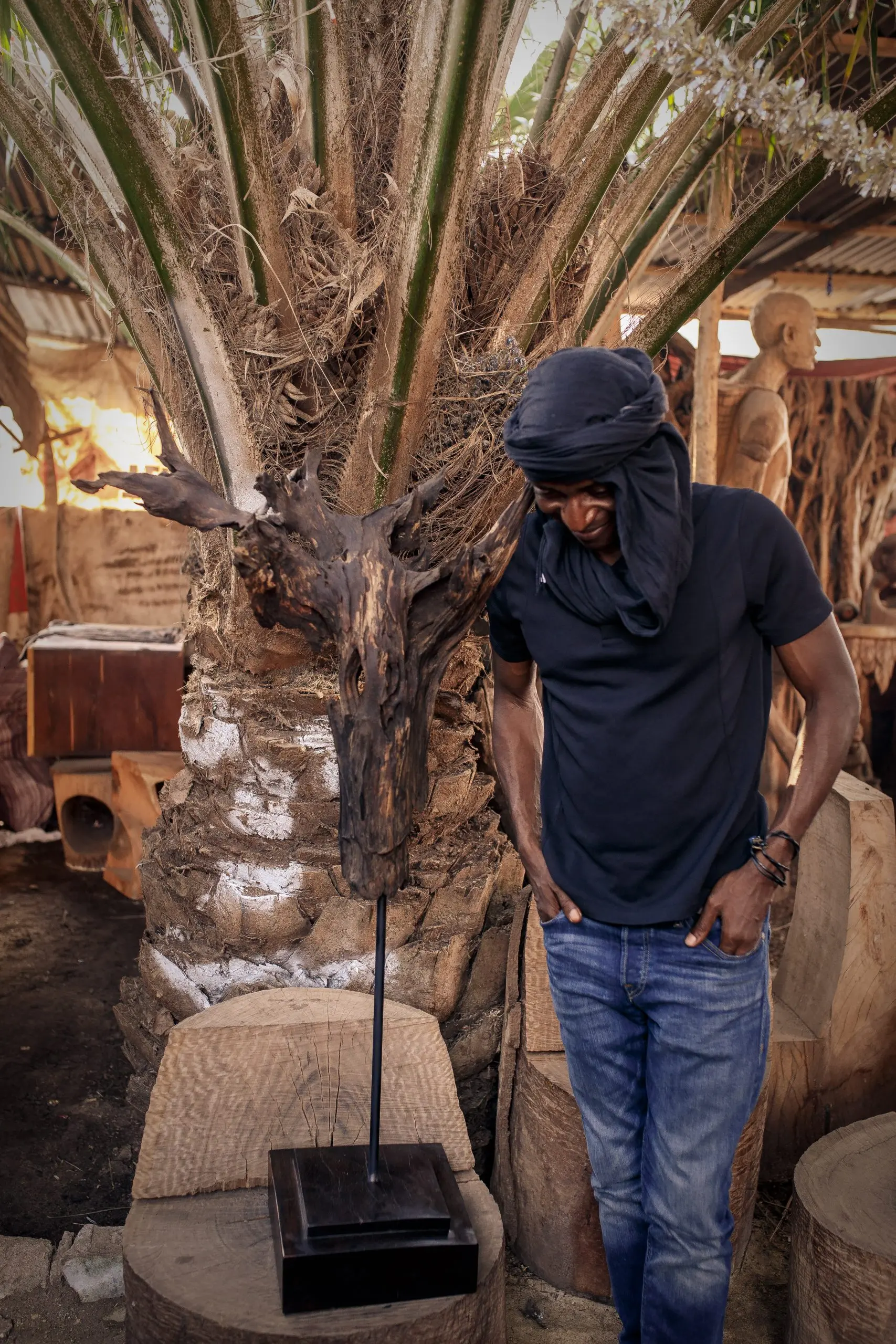 Richard Meseko beside a carved palm.