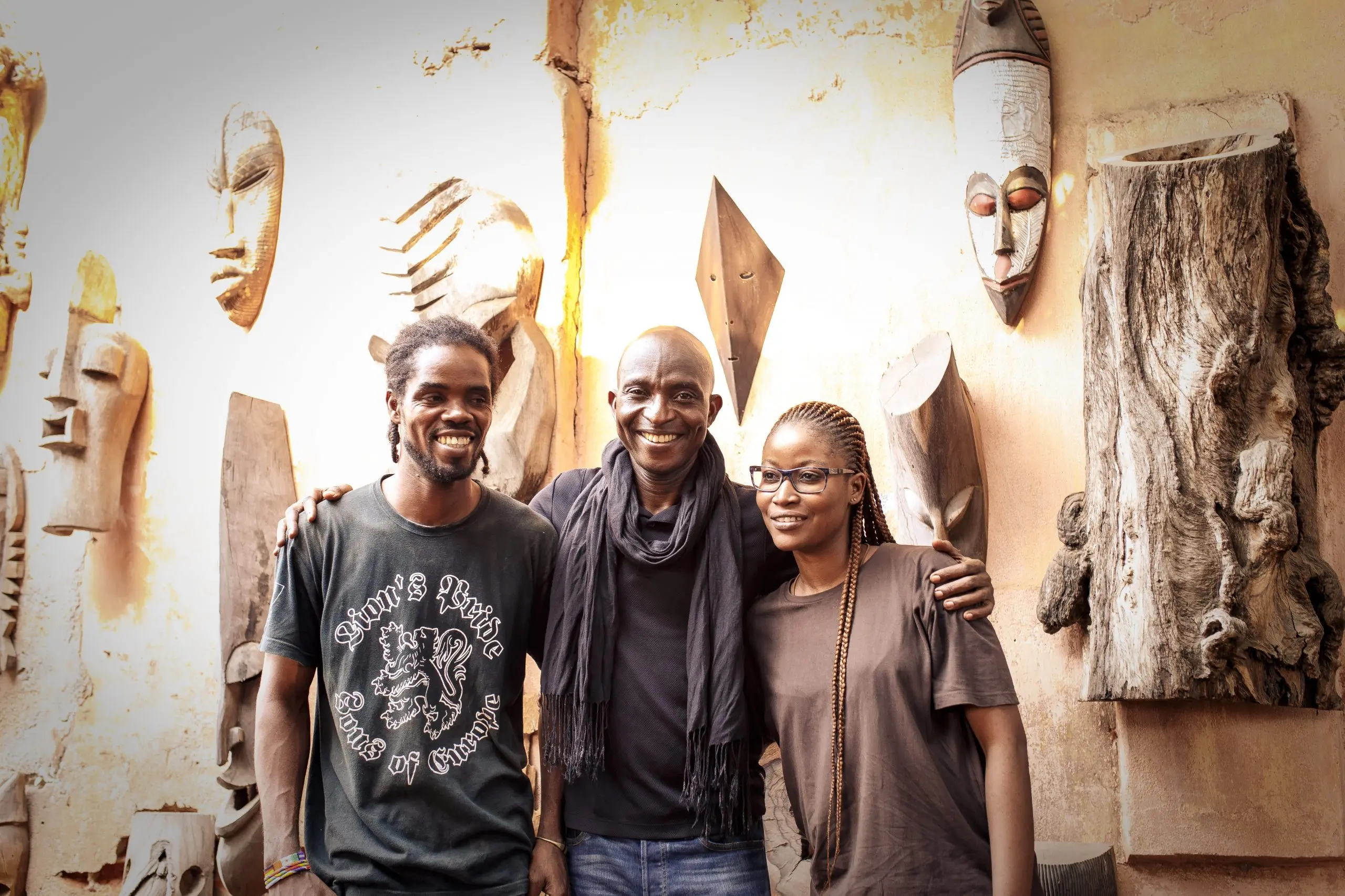 Richard Meseko with friends among carved masks.